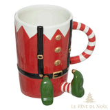 Tasse en forme de lutin, torse rouge à boutons dorés, jambes vertes, anse en canne de bonbon