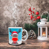 Mug blanc à motif renne au nez rouge et bonnet de Noël, vapeur montant de la tasse sur une table en bois