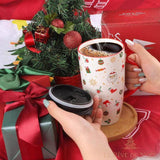Mug de Noël tenu à deux mains avec du café fumant, mini sapin et cadeaux en arrière-plan