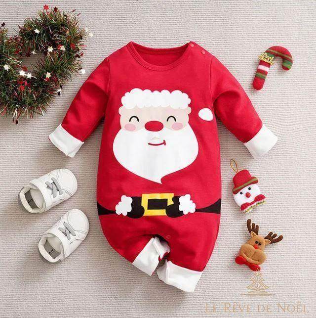 Body bébé rouge à visage de Père Noël et ceinture noire, posé à plat avec petites baskets blanches