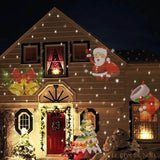 Façade de maison la nuit avec Père Noël, cloches et sapin projetés en motifs lumineux colorés
