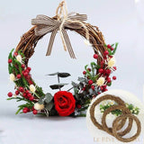 Couronne en rotin garnie de rose rouge, baies et fleurs séchées, nœud à carreaux ; encart de rotins nus