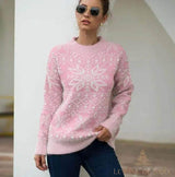 Pull rose à motif de flocon de neige blanc, cheveux relevés, porté avec un jean foncé
