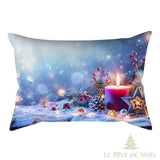 Housse de coussin illustrée d'une bougie rouge allumée sur fond bleuté enneigé, avec houx et pomme de pin