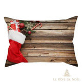 Housse de coussin à motif botte de Noël rouge remplie de cadeaux, sur fond de planches en bois