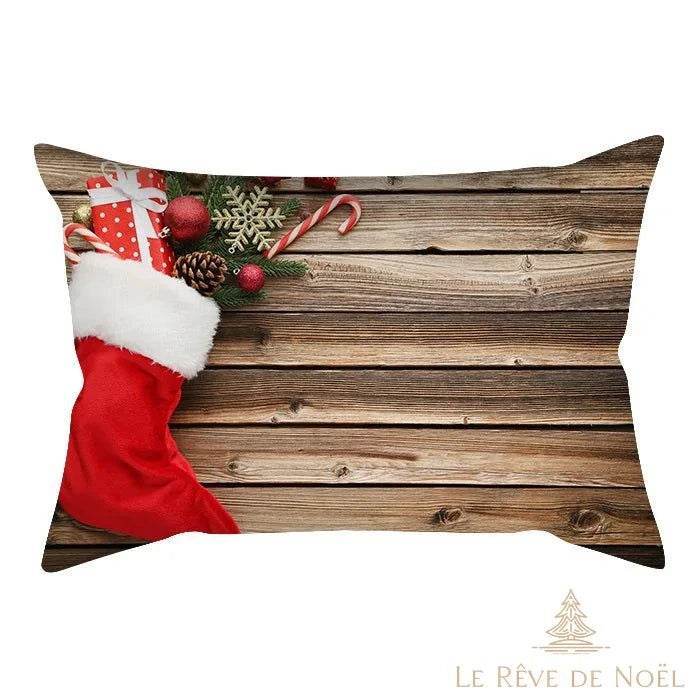 Housse de coussin à motif botte de Noël rouge remplie de cadeaux, sur fond de planches en bois