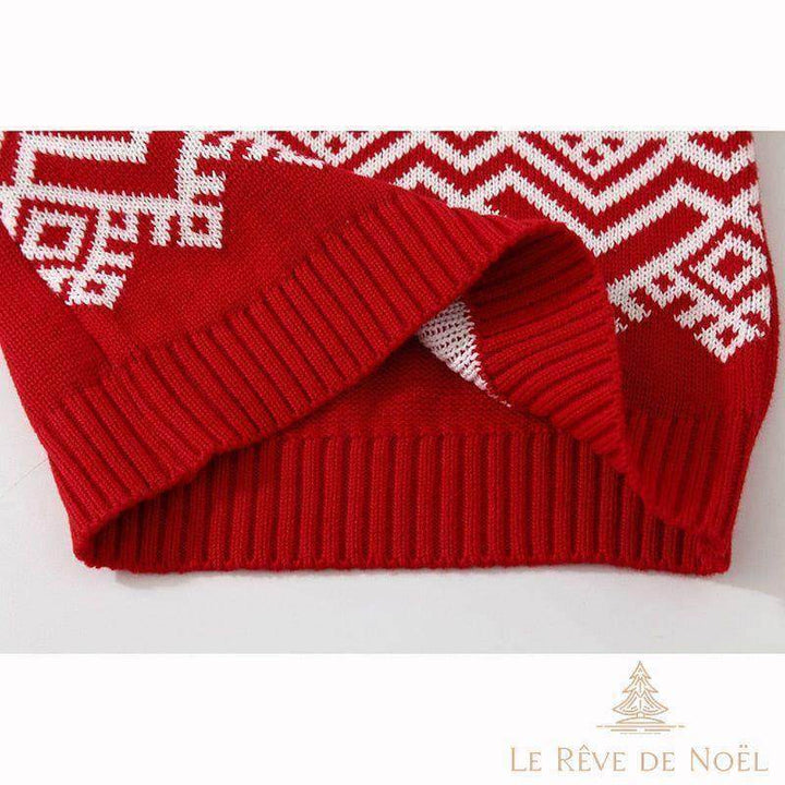 Gros plan sur le poignet rouge replié, tricot côtelé et motif géométrique blanc