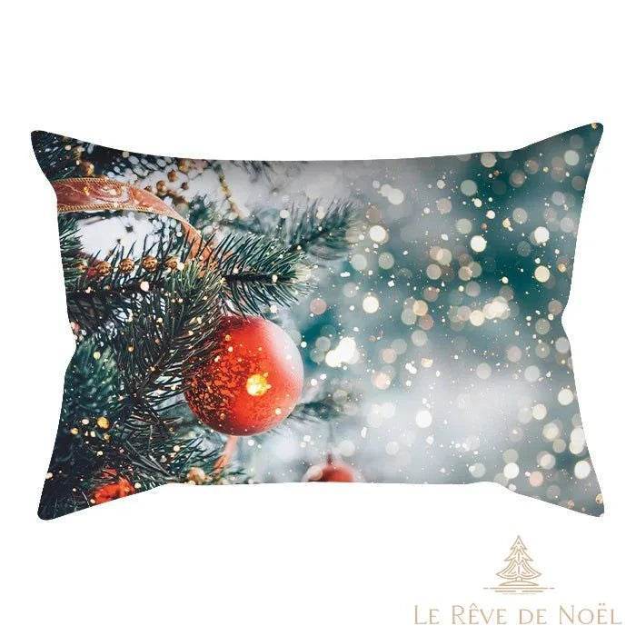 Housse de coussin, gros plan sur une boule de Noël rouge pailletée accrochée à un sapin