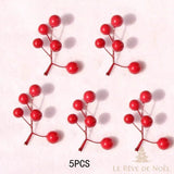 Cinq petites branches de baies rouges à ramification en Y, sur fond rose pâle
