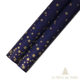 Deux rouleaux de papier cadeau bleu marine semés de petites étoiles dorées éparses