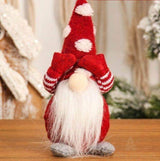 Lutin de Noël rouge, bonnet pointu à pois blancs, mains cachant le visage, longue barbe blanche