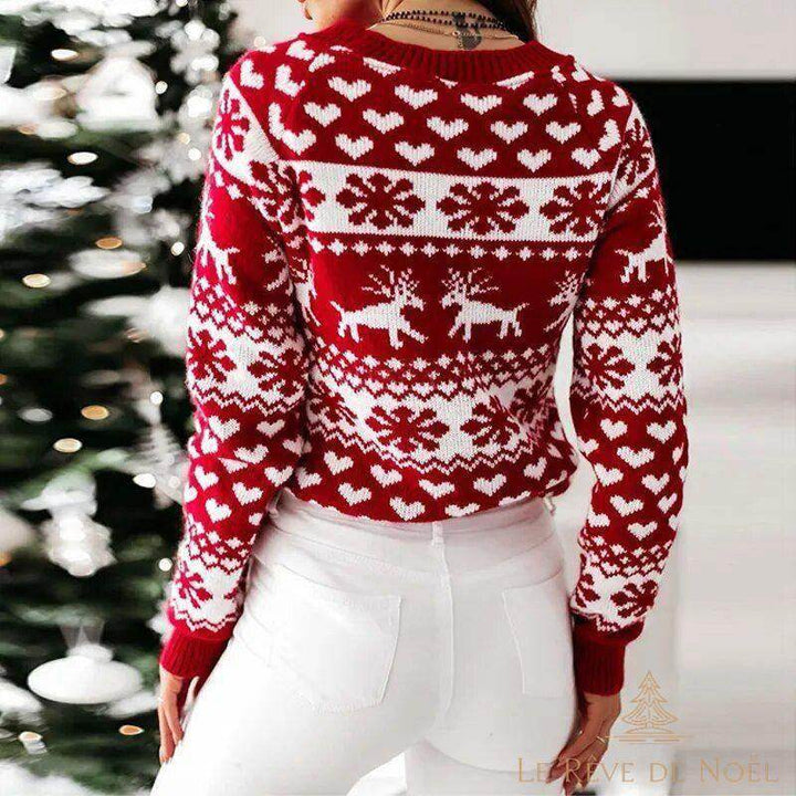 Pull de Noël rouge à motifs blancs, vu de dos, la femme se tient devant un sapin décoré