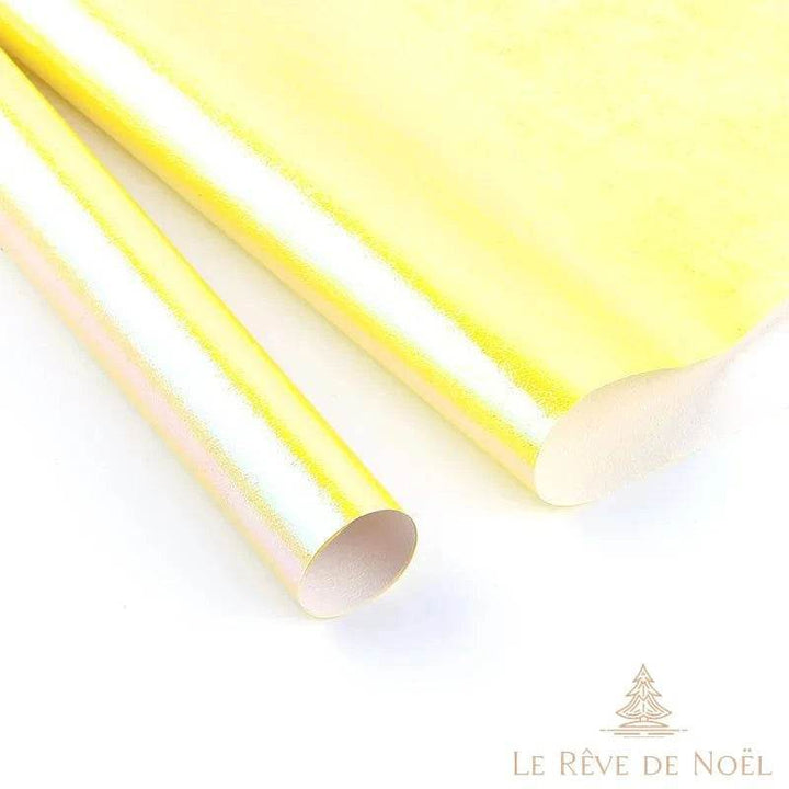 Deux rouleaux de papier cadeau brillant jaune pâle, feuille dépliée en arrière-plan