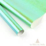 Deux rouleaux de papier cadeau brillant vert menthe irisé, feuille déroulée derrière