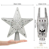 Schéma des dimensions du cimier étoile argenté : 25 cm de large, 27 cm de haut, tenu dans une main pour l'échelle