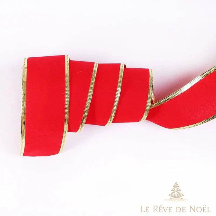 Ruban rouge mat à bordures dorées, plié en accordéon sur fond blanc