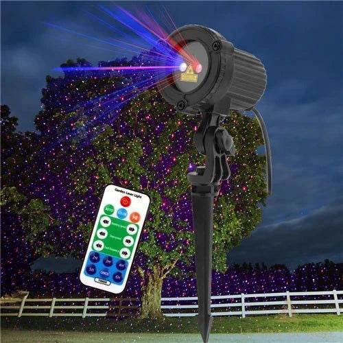 Projecteur sur piquet devant un arbre la nuit, nuage de points lumineux bleus et rouges sur le feuillage