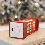 Boule à neige cabine téléphonique couchée, compartiment à piles ouvert et interrupteur visibles