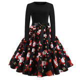 Robe de Noël noire, jupe à motif Père Noël, cadeaux emballés et cheminée sur fond noir