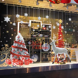 Vitrine de boutique la nuit : sapin blanc aux boules rouges et statue de renne blanc grandeur nature