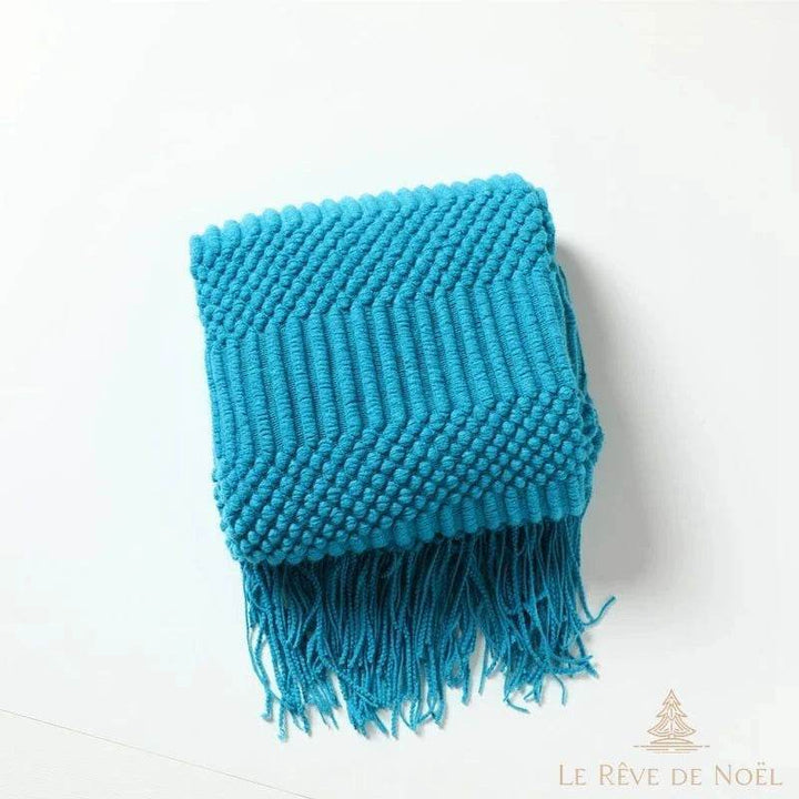 Plaid de Noël bleu turquoise plié, motif chevrons et picots en relief, franges devant