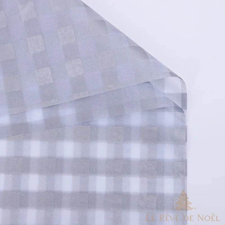 Papier cadeau à carreaux gris argenté et blanc, gros plan sur le coin de la feuille repliée