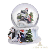 Boule à neige vue de face, igloo dans le globe, deux pingouins habillés posés devant le socle