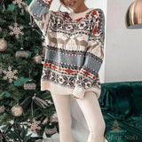 Pull de Noël beige à motif jacquard de rennes, souriante devant un sapin décoré