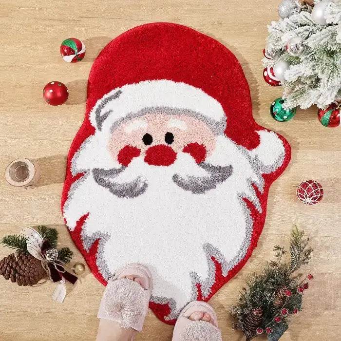 Tapis en forme de visage de Père Noël rouge et blanc, chaussons roses posés dessus au sol