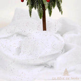 Tapis de neige pailleté drapé en volume autour du pied d'un sapin miniature givré