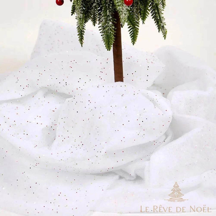 Tapis de neige pailleté drapé en volume autour du pied d'un sapin miniature givré