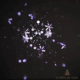 Effet de flocons de neige projeté par le projecteur de Noël, motifs blancs et violets dans le noir