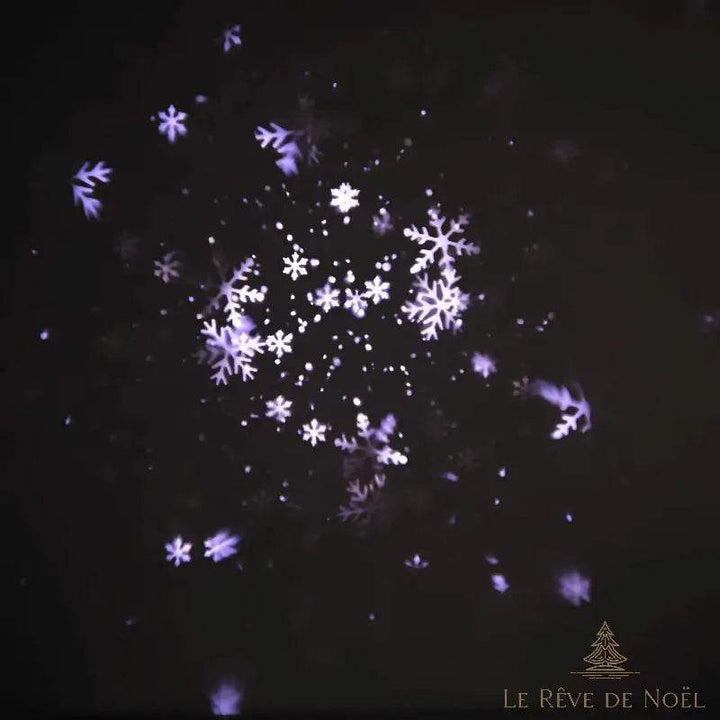 Effet de flocons de neige projeté par le projecteur de Noël, motifs blancs et violets dans le noir