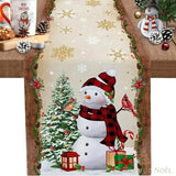 Chemin de table beige à flocons dorés et bordure de houx, bonhomme de neige en bonnet à carreaux rouges et oiseau cardinal