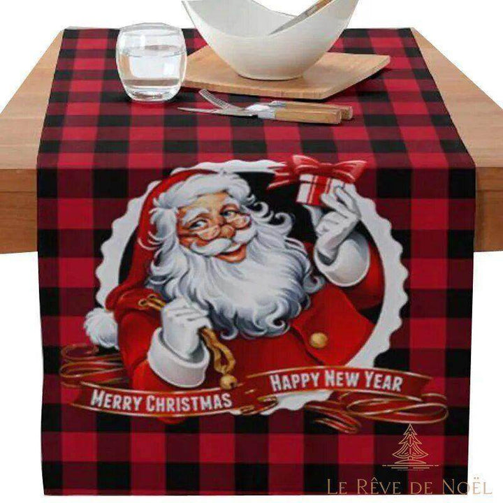 Chemin de table à carreaux rouge et noir avec portrait du Père Noël, dressé sur une table en bois