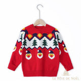 Pull enfant rouge à motif sapins et visages du Père Noël, sur cintre en bois