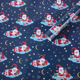 Rouleau de papier cadeau bleu marine, motif répété de Père Noël sur un nuage, lunes et étoiles dorées