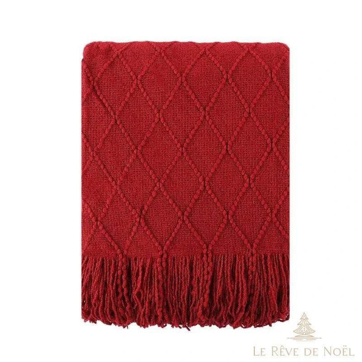Plaid de Noël en maille rouge à motif losanges, posé à plat, longues franges torsadées