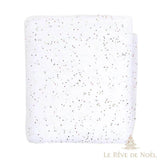 Rouleau de tapis de neige blanc plié, tissu semé de fins paillettes rouges, vertes et dorées