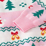 Gros plan sur le poignet rose du pull, manche à motif de sapins verts brodés