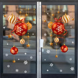 Stickers de boules rouges et dorées et flocons blancs sur une porte vitrée, poignée et rue visibles