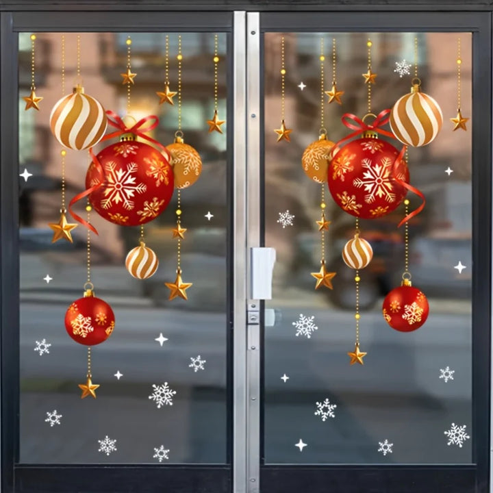 Stickers de boules rouges et dorées et flocons blancs sur une porte vitrée, poignée et rue visibles