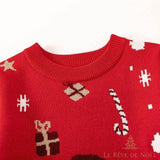 Gros plan sur le col côtelé rouge du pull, détail des motifs cadeaux et sucre d'orge