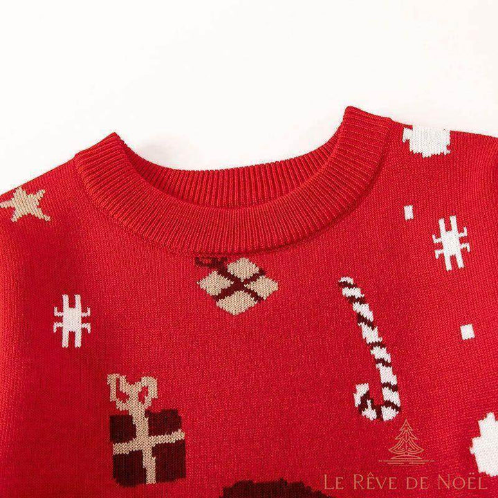 Gros plan sur le col côtelé rouge du pull, détail des motifs cadeaux et sucre d'orge