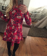 Robe de Noël moche rouge à grosses têtes de rennes façon Rudolph, sur un parquet en bois