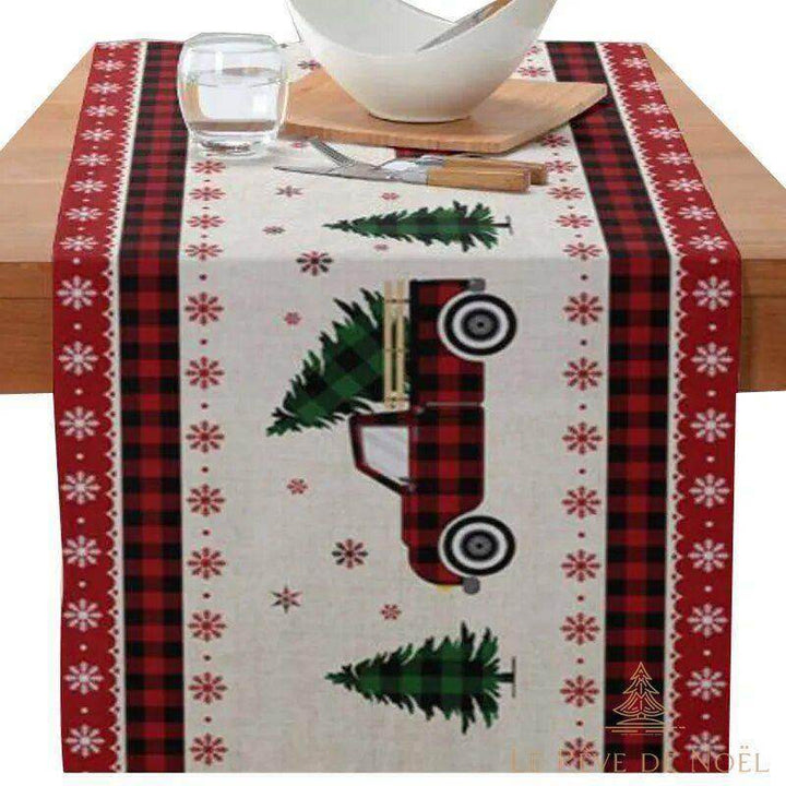 Chemin de table avec camion à carreaux transportant un sapin, petits sapins et flocons imprimés