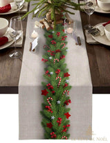 Chemin de table beige avec guirlande de sapin, baies rouges et cannes de bonbon, table dressée