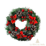Couronne de sapin avec fleurs de poinsettia rouges, pommes de pin et grappes de baies rouges