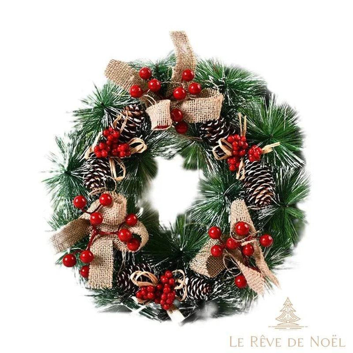 Couronne de sapin avec nœuds en toile de jute, pommes de pin enneigées et baies rouges groupées