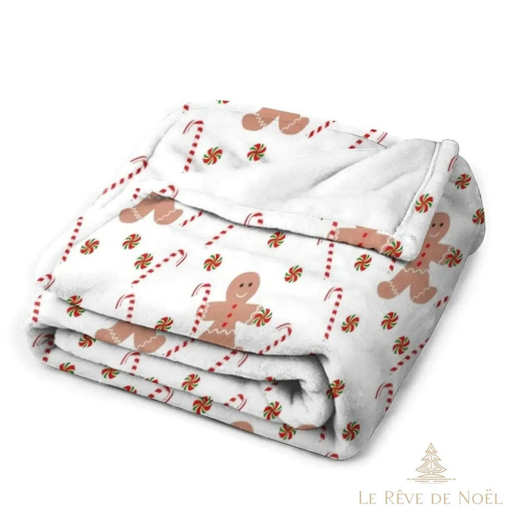 Plaid beige plié montrant les motifs bonhommes en pain d'épice et sucres d'orge